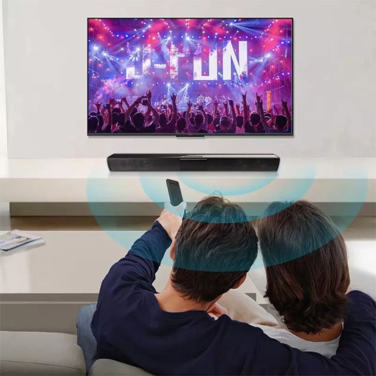 Barre de son PC sous la télévision avec couple qui regarde