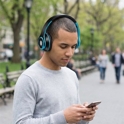 Casque audio sans fil noir bleu homme en promenade écoute musique avec iphone 