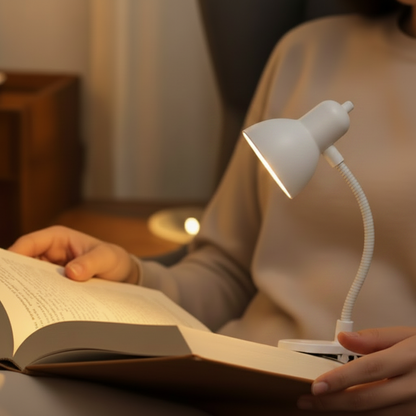 Lampe de lecture en blanche  au bas clip univerel sur  livre, femme qui fait la lecture au salon 